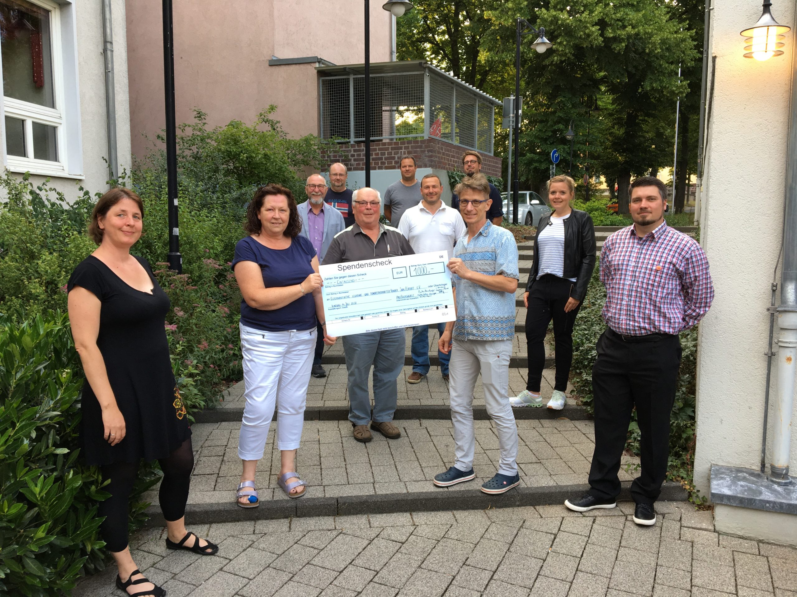 Vertreter von Pro Bockwurst überreichen den Spendencheck an die Vertreterin der Elterninitiative